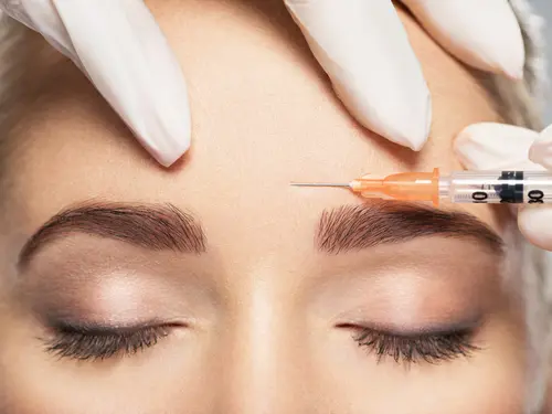 Woman receiving injectable filler above eyes